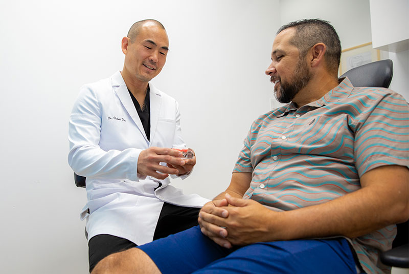 Doctor showing patient implant model